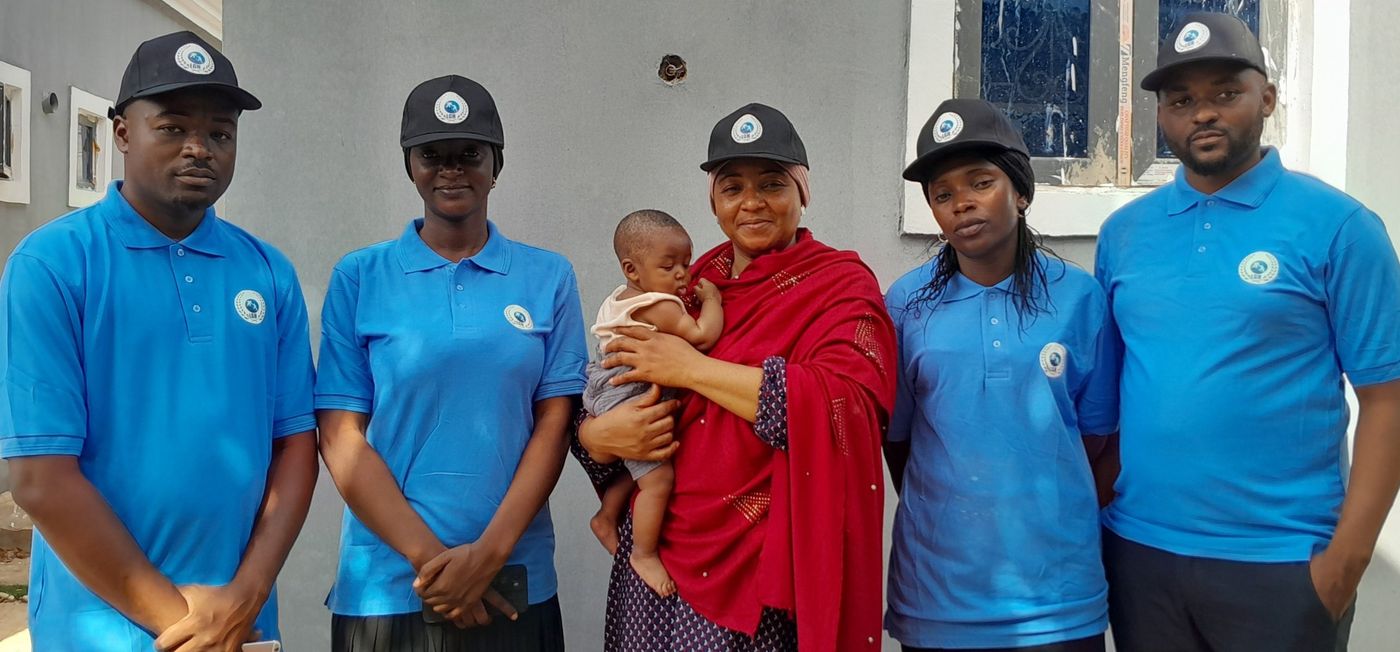 Members of the team in matching blue shirts and black caps carrying the foundation emblem